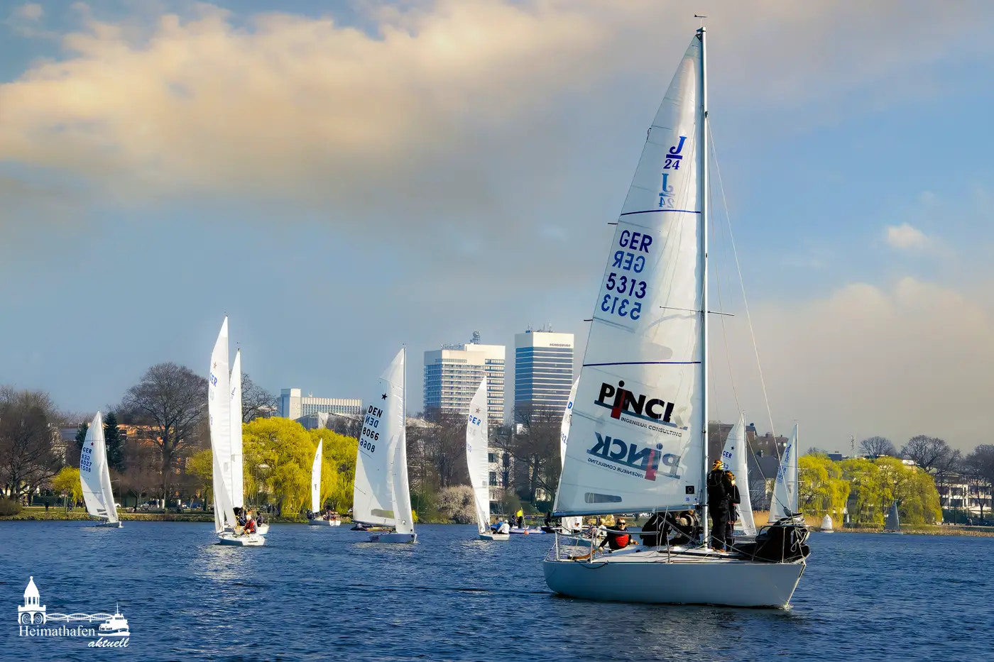 Segelboote auf der Alster im Frühlingswind vor Hamburger Skyline