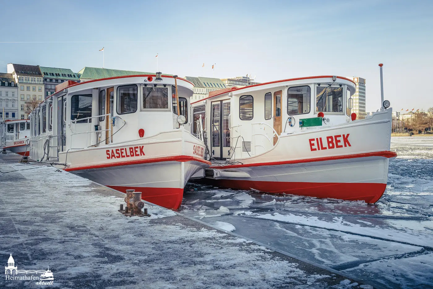 Zwei Alsterdampfer im Winter am vereisten Jungfernstieg in Hamburg.