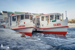 Zwei Alsterdampfer im Winter am vereisten Jungfernstieg in Hamburg.