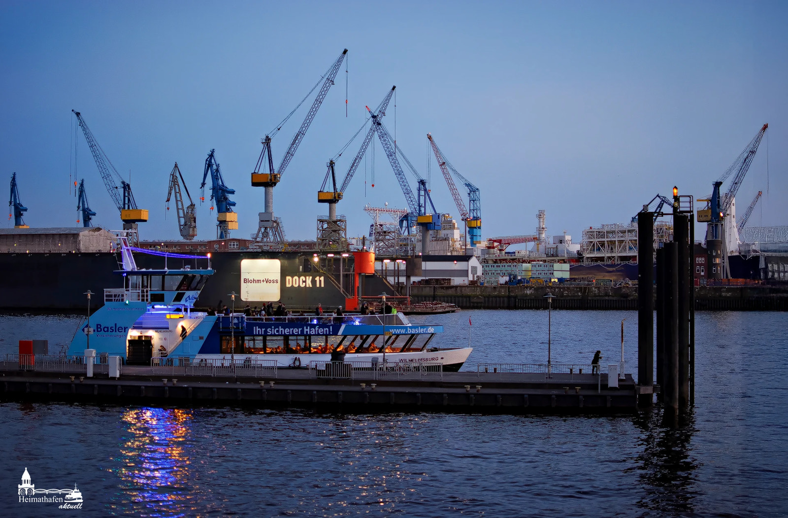Fähranleger Altona mit Blick auf Dock 11 und Werftkräne in der blauen Stunde
