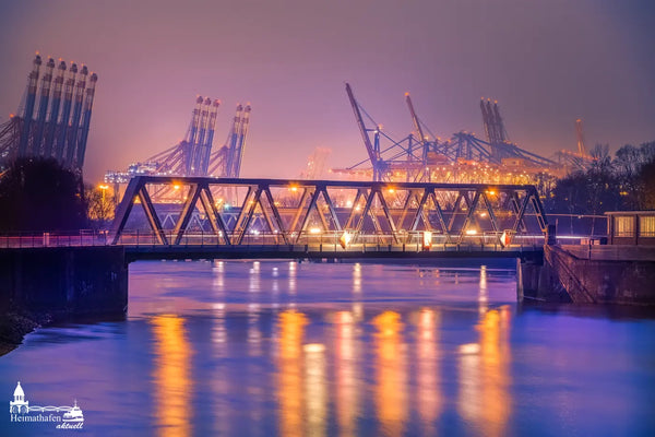 Brücke im Hamburger Hafen am Abend mit Hafenkränen und Lichtern im Nebel