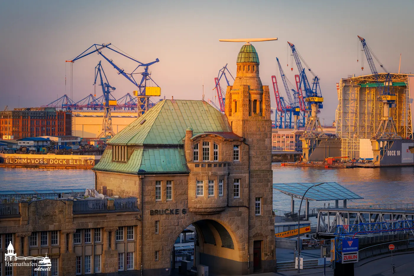 Der Pegelturm an den Landungsbrücken in Hamburg bei Sonnenaufgang mit Blick auf die Werft.
