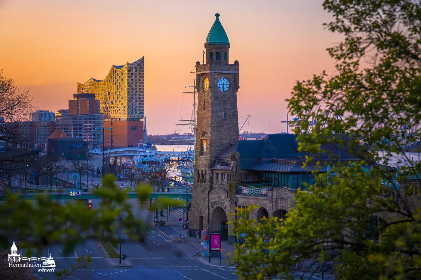Pegelturm an den Landungsbrücken mit Blick auf die Elbphilharmonie bei Sonnenaufgang.