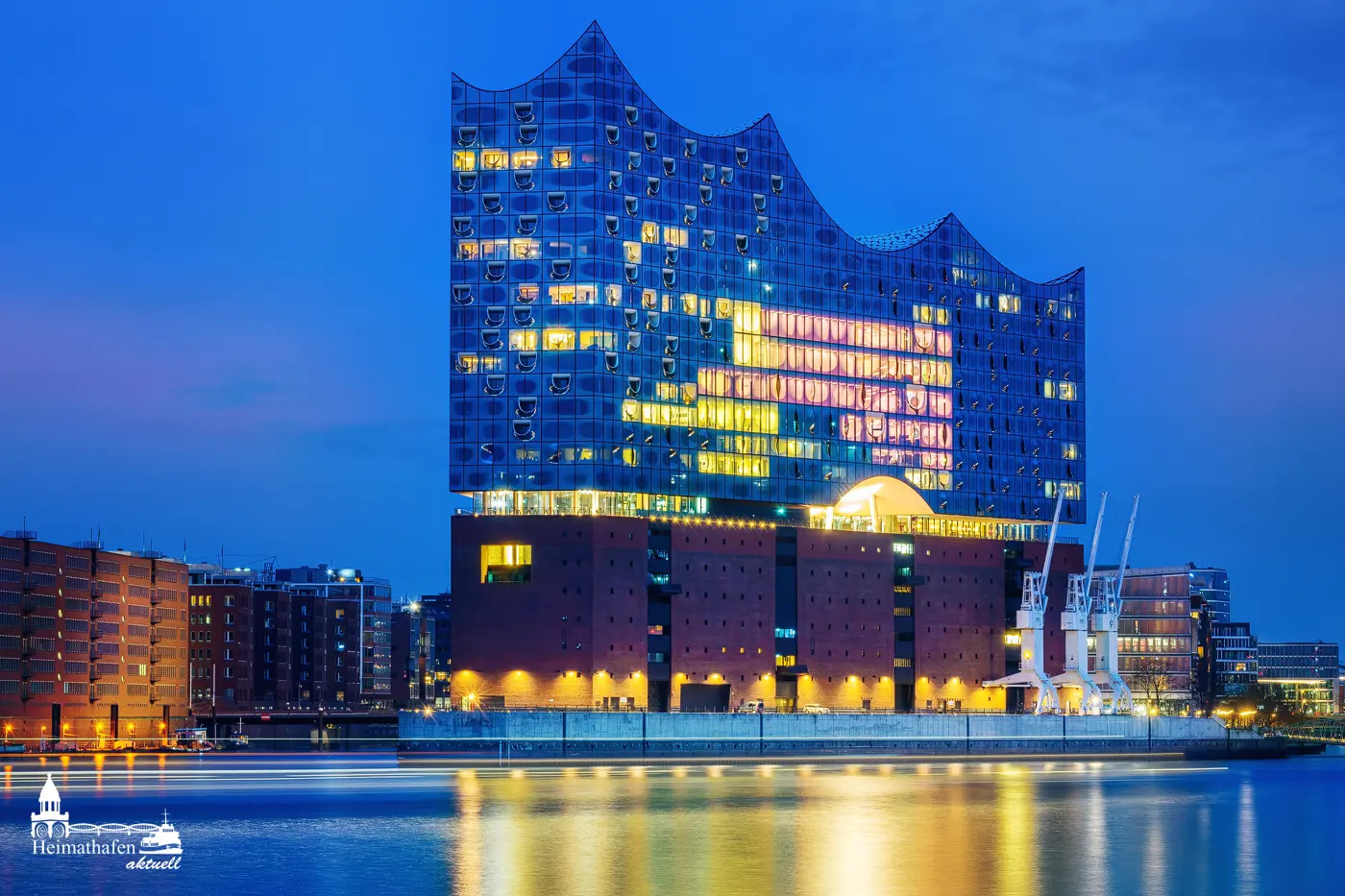 Elbphilharmonie bei Nacht in der blauen Stunde mit Spiegelung in der Elbe