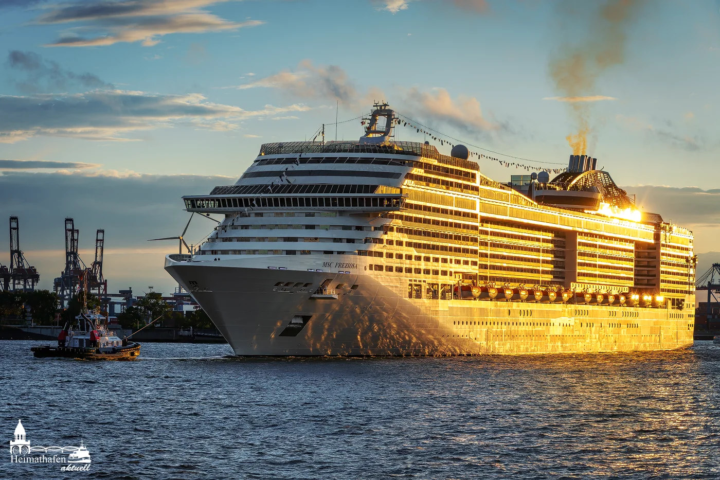 Kreuzfahrtschiff MSC PREZIOSA leuchtet im goldenen Sonnenuntergang, begleitet von einem Schlepper im Hamburger Hafen.