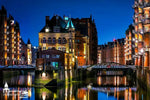 Wasserschloss in der Hamburger Speicherstadt bei Nacht, leuchtend und gespiegelt im Wasser