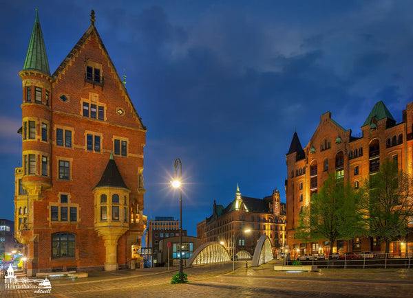 Beleuchtete Speicherstadt in der Hamburger HafenCity bei Abenddämmerung mit Brücke und historischen Gebäuden