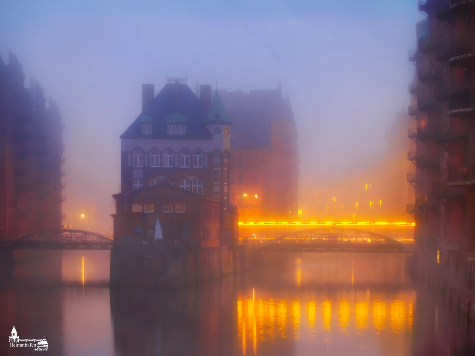 Wasserschloss Hamburg im Morgennebel bei Sonnenaufgang, stimmungsvolle Lichter und Spiegelungen in der Speicherstadt
