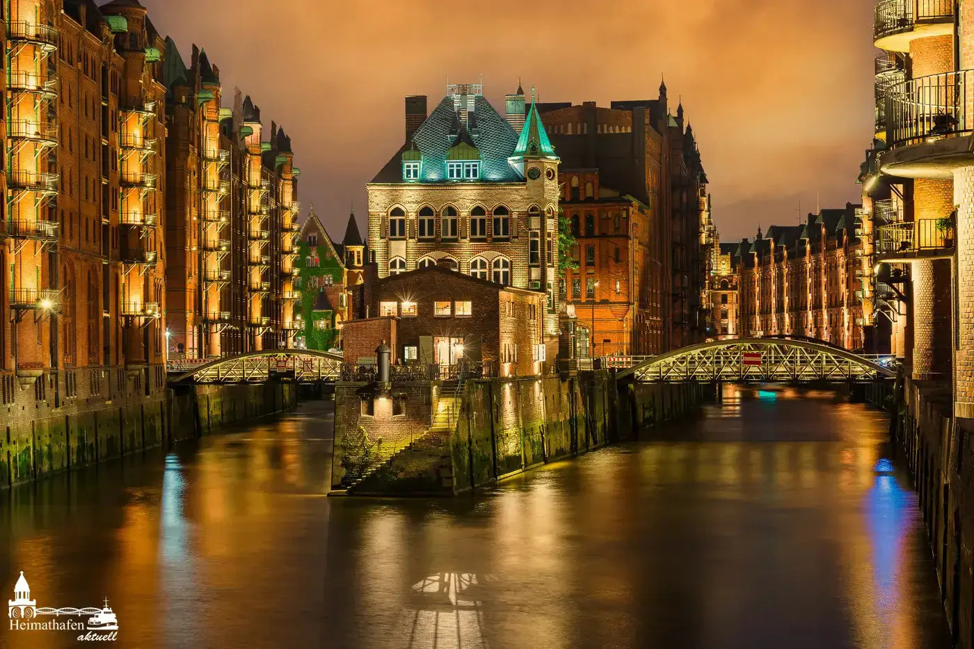 WASSERSCHLOSS in der Hamburger Speicherstadt bei Sonnenuntergang mit goldener Beleuchtung und Spiegelung im Wasser