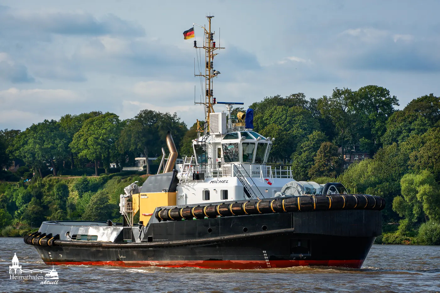 Hafenschlepper MICHEL auf der Elbe vor grüner Kulisse bei Hamburg
