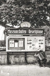 Schwarzweißfoto vom Museumshafen Oevelgönne mit Akkordeonspieler vor Infotafel